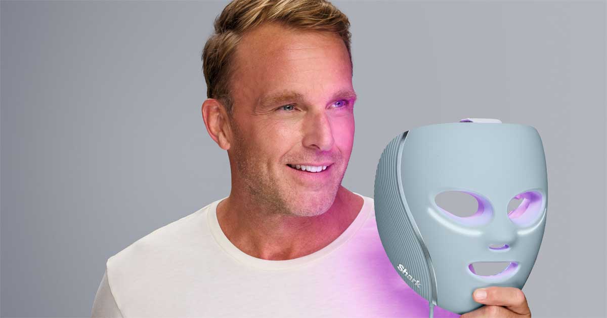 Man holding an LED face mask with cooling and light technology.