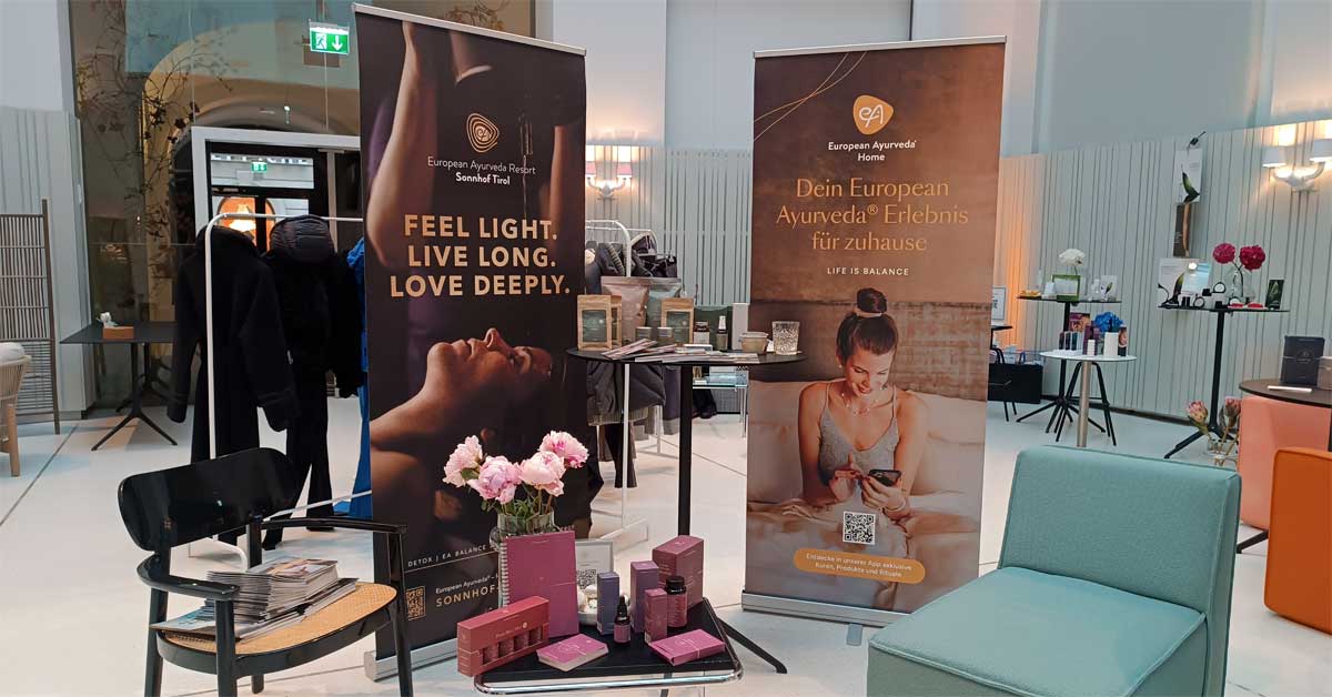 Presentation stand of the European Ayurveda Resort Sonnhof at a press day in Vienna, showing wellness products, information displays and the European Ayurveda Home concept.